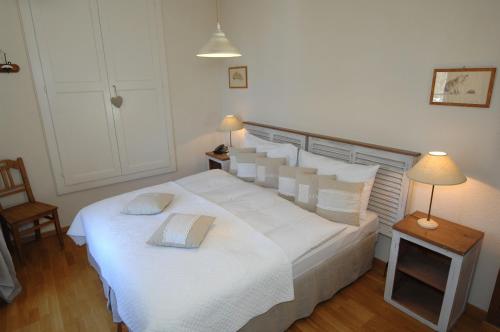 格兰瓦克斯奥伯格火车站酒店的卧室配有一张白色的床,上面有书