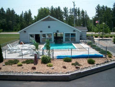 麦基诺城日出海滩汽车旅馆的一座房子前面设有游泳池