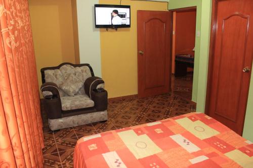 瓦拉斯Residencial Norandes的一间卧室配有椅子和墙上的电视
