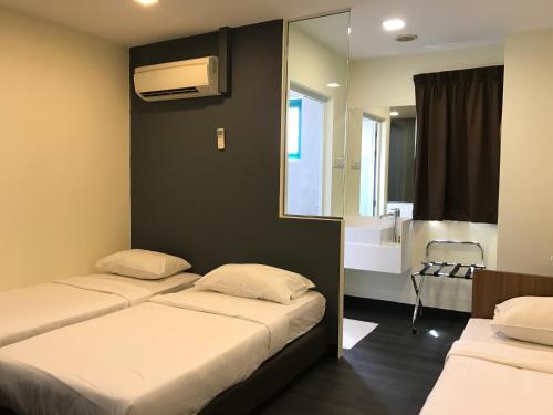 新加坡L Hotel at 51 Desker的客房设有两张床和一间带镜子的浴室