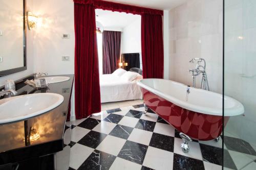 圣乔瓦尼-因马里尼亚诺海滨高尔夫度假酒店的一间带两个盥洗盆、一个浴缸和一张床的浴室