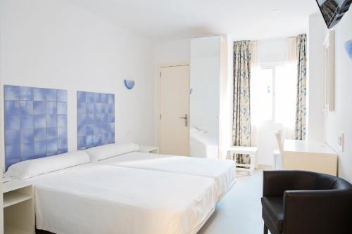 马拉加艾利斯欧斯酒店的白色卧室配有床和椅子