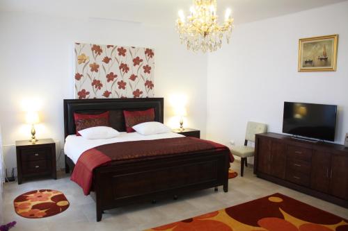 布拉索夫Casa Graef的一间卧室配有一张床、一台电视和吊灯。