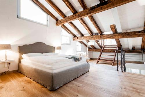 博尔扎诺Stay COOPER l Laubenhaus的一间卧室设有一张大床和木制天花板。