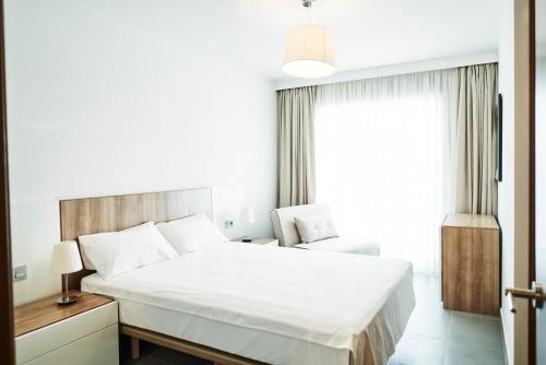 厄尔梅达诺Luxury Apartment Las Terrazas的卧室设有一张白色大床和一扇窗户。