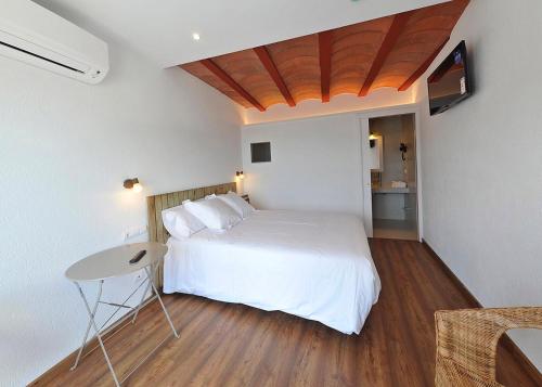 卡达克斯卡达克阿莱斯成人酒店的卧室配有白色的床和桌子