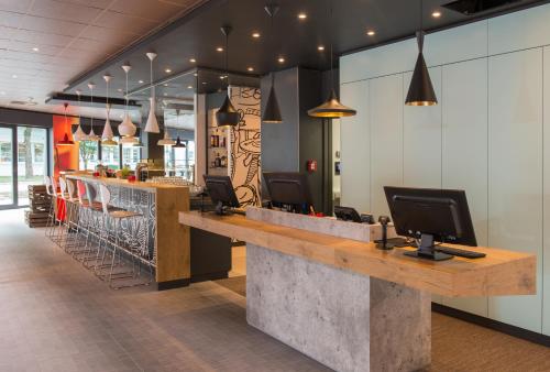 哈尔伯格摩斯慕尼黑机场南宜必思酒店的餐厅设有酒吧,柜台上配有电脑