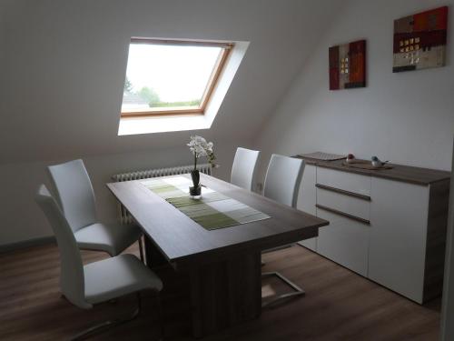 卡斯特罗普-劳克塞尔Apartment 1G的餐桌、白色椅子和窗户