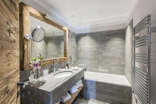 切勒里纳霍特力诺佩蒂特小木屋旅馆的一间带水槽、浴缸和镜子的浴室