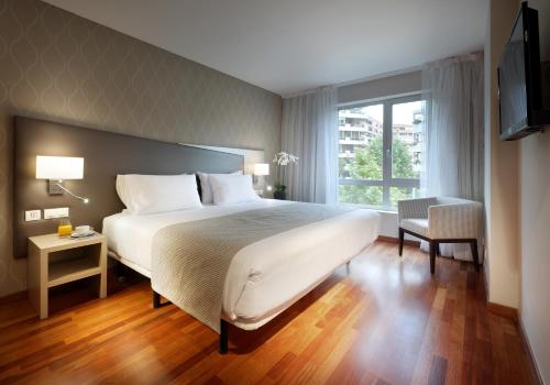 萨拉戈萨WTC埃克萨拉戈萨酒店的卧室设有一张白色大床和一扇窗户。