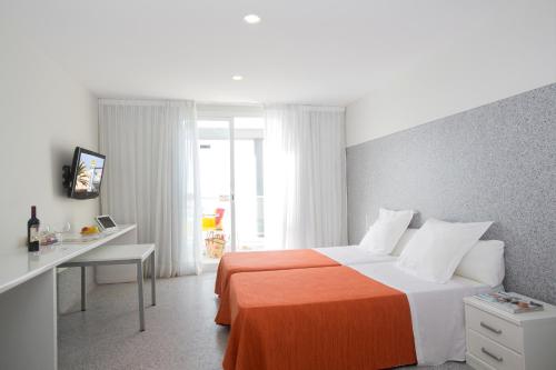 埃尔阿雷纳尔巴伊亚皇家酒店的一间卧室配有一张床和一张书桌及电视
