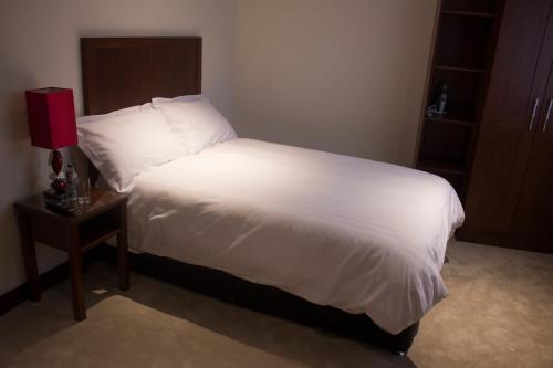 Beaumont博蒙特之家旅馆的一间卧室配有一张带白色床单和一张桌子的床。