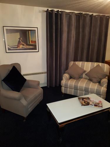 邓甘嫩科汉诺旅馆的客厅配有两把椅子、一张沙发和一张桌子