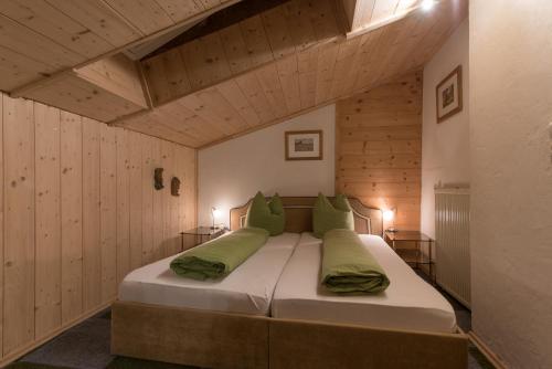 佩特诺伊阿尔贝格Gasthof zur Traube的木墙客房内的一张大床