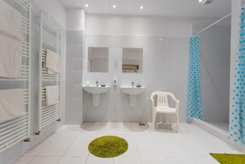 圣格奥尔基Green Hostel的浴室设有2个水槽和1把白色椅子