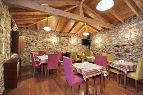 安德里塞纳Archontiko的一间带桌椅和石墙的餐厅