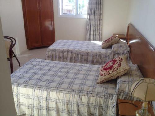 SelouaneMotel Paris Dakar的卧室设有两张单人床和窗户。