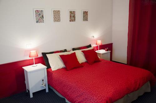 瓦尔迪佐多阿尔索尔旅馆的一间卧室配有红色的床和2个床头柜