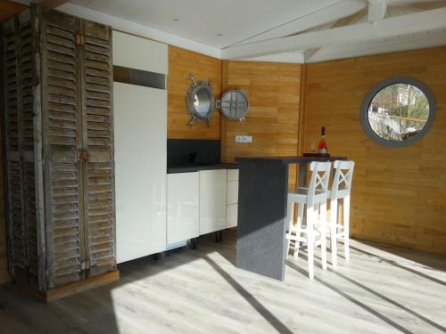 索米尔别样假日船屋的厨房设有木墙和带凳子的台面。