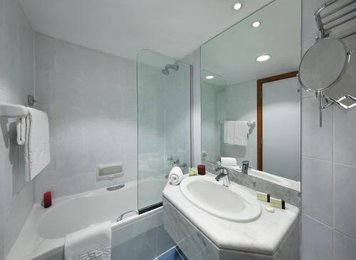 迪拜海军上将广场酒店的白色的浴室设有水槽和淋浴。