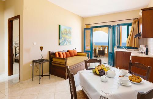 阿尔卡萨爱琴海公寓的厨房以及带水果桌的起居室。