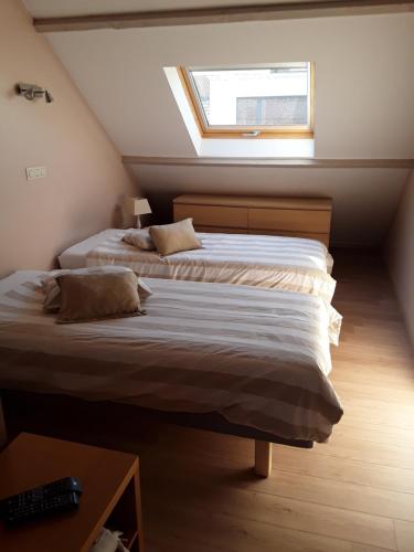 Scherpenheuvel-Zichem温兹拉斯科博尔格度假屋的阁楼卧室设有两张床和窗户。