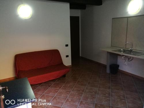 Bossolasco达维迪农家乐的客厅配有红色沙发和水槽