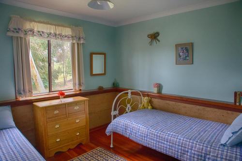 巴林巴林加木屋的一间卧室设有两张床、一个梳妆台和窗户。