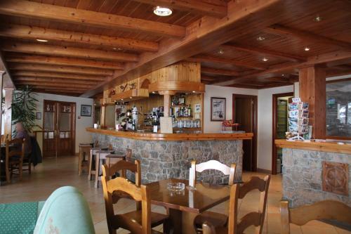 索尔德乌索尔德乌斯特尔酒店的一间设有木制天花板的餐厅和一间石头酒吧