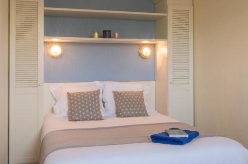 拉卡诺Residence Lacanau Bleu Marine - maeva Home的一间卧室配有带两个枕头和灯的床