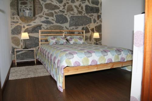 Vila da LixaQuinta da Costa的一间卧室配有一张木床和石墙