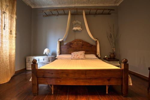 RovietoLa mia casa di campagna的一间卧室配有一张木床和挂床架
