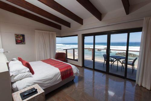 普利登堡湾亚赤洛克度假酒店的一间卧室设有一张床和一个海景阳台