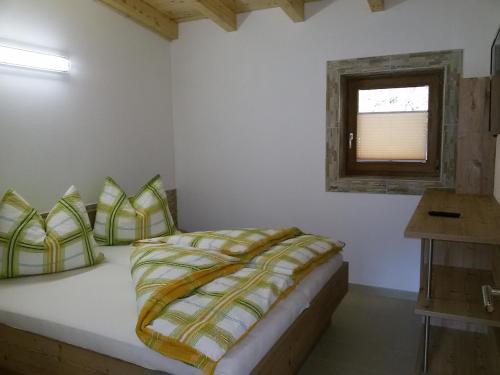 兰格尔斯道夫Klenig Hof的一间卧室配有一张带黄色和绿色枕头的床