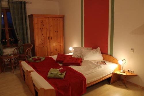 阿姆施泰滕Pihringer's Moststub'n的一间卧室配有一张带红色和白色枕头的大床
