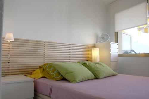 坎布里尔斯Synergie SI14 - Sol Daurat的一间卧室配有一张带绿色和黄色枕头的床