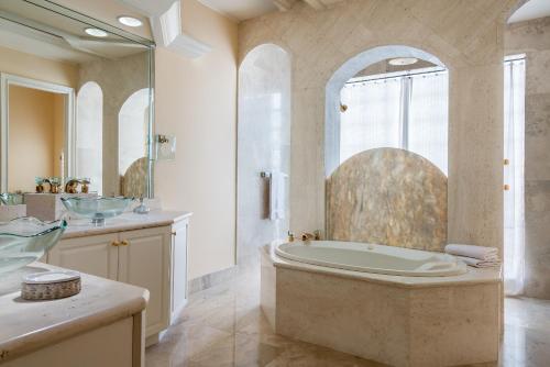 马可岛奥尔德马可岛套房及宾馆的大型浴室设有浴缸和淋浴。