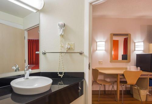 惠特比莫特尔6号汽车旅馆 - 多伦多东 - 惠特比的一间带水槽的浴室和一张带镜子的书桌