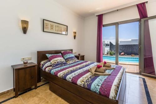 普拉亚布兰卡Villa el Faro的一间卧室设有一张床,享有游泳池的景色