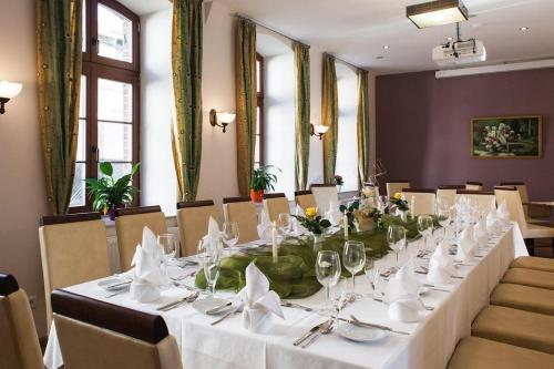 普劳西Hotel und Restaurant Haus Sajons的一张长桌,配有白色桌布和餐巾