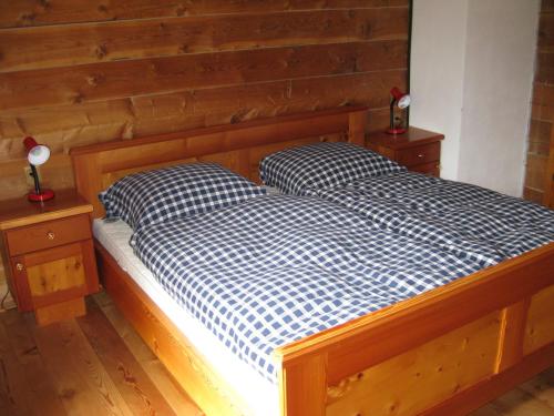 海利根布卢特Almhütte Adlerhorst的一张木制床,上面有两个枕头