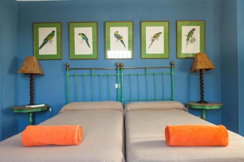 BobadillaCaseria San Jose的卧室配有两张床,墙上挂有鸟的照片