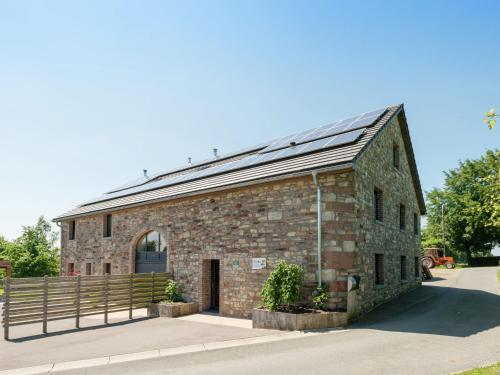 韦姆Heritage Holiday Home in Ovifat with Sauna的一座拥有太阳能屋顶的旧砖砌建筑