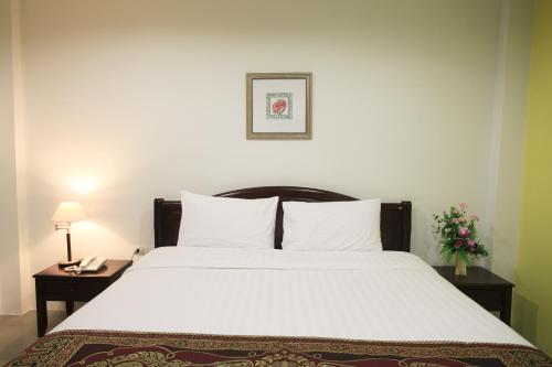 曼谷苏22号公寓的一间卧室配有一张带2个床头柜的大型白色床