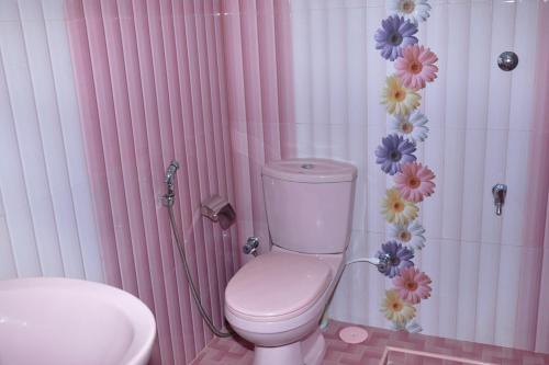 奇洛Hotel Pearl Gate的粉红色和白色的浴室设有卫生间和水槽