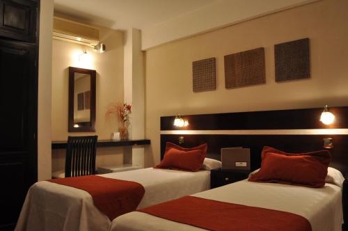 圣萨尔瓦多德朱格雷戈里奥一世精品酒店的酒店客房 - 带两张带红色枕头的床