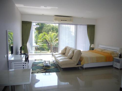 卡伦海滩Chic Condominium Unit A303, A306, A307, A308, A406的一间卧室配有一张床、一张沙发和一张书桌