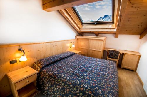 博尔米奥花园酒店的一间卧室设有一张床和一个大窗户