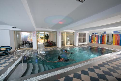 萨尔巴赫伯杰体育酒店的一座大型游泳池,其中有两人游泳
