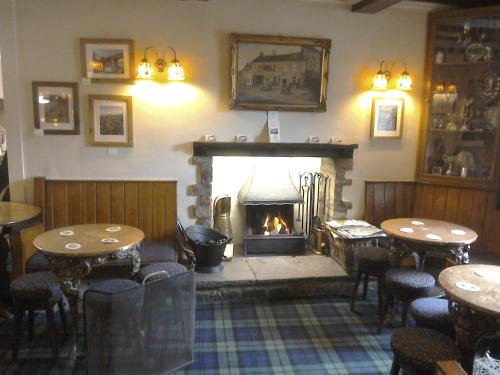 格拉辛顿The Foresters Arms的餐厅的壁炉,配有桌子和壁炉